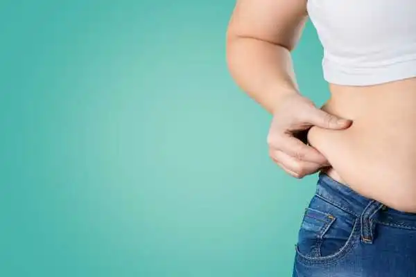 Image of woman pinching her love handles to show weight gain Spring Vale
